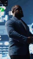 Vertical Tech savvy black male engineer reviewing big data AI brain using cloud computing tools and advanced programming for virtual assistant development and IT automation systems. Camera B. video