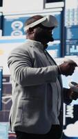 Vertical Young startup administrator reviews big data with virtual reality headset, working hard on business growth to increase profit. Analyzing monthly reports for productivity and success. Camera B. video