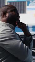 Vertical Modern black entrepreneur thinking about new powerful ideas to obtain funds, reviewing data insights for the financial and KPI projections decision making. Forecasting for productivity. Camera B. video
