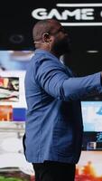 Vertical African american host at digital event engages the audience with insights on social media trends, e commerce and engagement using apps or web platforms. Real time data visualization. Camera A. video