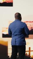 Vertical Black person does meditation pose with hands together in prayer, radiating inner peace and spiritual devotion. Surrounded by images of the cross, serenity and divine connection. Camera A. video