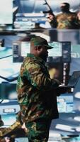 Vertical Defense forces officer reviews surveillance and digital systems, getting combat ready with warfare strategies and battlefield details. War planning operations in military control center. Camera A. video