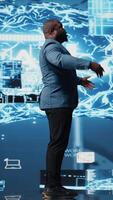 Vertical Tech savvy black male engineer reviewing big data AI brain using cloud computing tools and advanced programming for virtual assistant development and IT automation systems. Camera A. video
