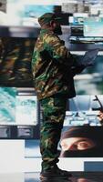 Vertical Officer monitoring real time combat data using advanced military systems, cyber tactics and digital surveillance to ensure battlefield control and strategic defense. War planning. Camera A. video