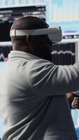 Vertical High tech startup entrepreneur using virtual reality glasses to examine KPI models, reviewing infographics and working on business productivity. Professional VR gadget simulation. Camera B. video