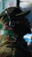 Vertical Black soldier guiding troops with satellite coordinates to create tactics, high tech control center for a mission. Soldier transmitting threat detection insight for national safety. Camera B. video