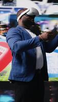 Vertical African american influencer using virtual reality glasses in mobile apps world, examining cloud data, visual content and emphasizing presence across tech platforms and social networks. Camera A. video