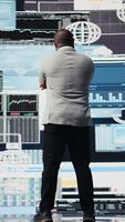 Vertical African american guy reflecting on annual financial reports for new development, reviewing the complexity of performance analysis with a focus on productivity and forecasting, AI tools. Camera A. video