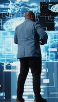 Vertical African american engineer examining artificial intelligence brain systems using cloud computing tools and advanced programming. Using machine learning for virtual assistant automation. Camera A. video