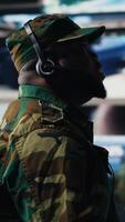 Vertical African american trooper keeping in touch with the mission control tower, collecting crucial satellite information through imagery. Transmitting important territorial data. Camera B. video