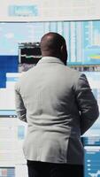 Vertical Modern business manager thinking about new successful ideas to increase his profit and develop the company, using insight and KPI projections or models for strategic decision making. Camera A. video