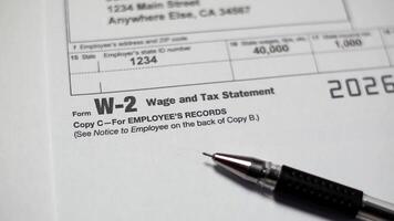 Tax document for the IRS W-2 Tax form on wooden table in office or at home video