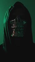 Vertical Masked hacker in hoodie looking into camera lens video