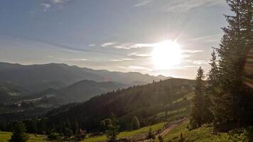 tramonto lasso di tempo al di sopra di carpazi montagne, caldo leggero al di sopra di foreste colline e dissolvenza cielo illuminante tranquillo, calmo rurale paesaggio durante sereno sera nel estate video