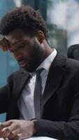 Tired African American man working web online with computer businessman male bored guy business depressed unhappy sad manager employer entrepreneur in office exhausted worker fatigue overwork indoor video