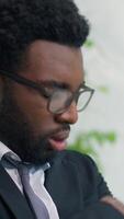 Vertical view stress African American business man worried panic attack suffering anxiety problem businessman male worker in office leaning against window thinking trouble nervous work failure emotion video