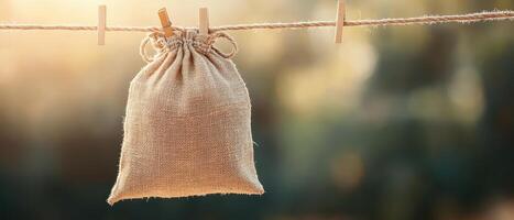 Small Burlap Bag Hangs on Clothesline with Clothespins Promoting Zero Waste Living Sustainable Concept photo