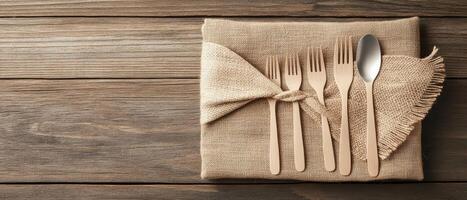 Wooden Forks Spoons Jute Fabric on Rustic Table Surface Concept of Zero Waste Living Tableware Close Up Flat Lay photo