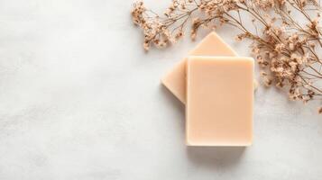 Two Soap Bars Resting Near Dried Flowers on Light Surface for Zero Waste Living Concept photo