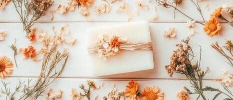 White Soap Bar Decorated with Twine on White Wooden Surface Surrounded by Dried Flowers for Zero Waste Living photo