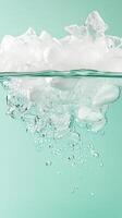 Clear Ice Formation Sinking into Cool Liquid with Bubbles against Plain Green Background for Zero Waste Living Concept photo