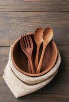 Wooden Utensils Rest Inside Bowl On Burlap Cloth Over Brown Wood Surface Showcasing Zero Waste Living Concept photo