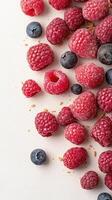 Scattered Raspberries and Blueberries with Crumbs on a White Surface for Gluten Free Low Carb Dessert Concept photo