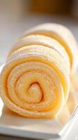 Close up view of a Spiral Rolled Dessert, a Gluten Free and Low Carb Sweet Treat, coated with white powder on a white plate. photo