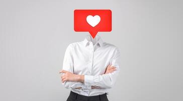 A person in business attire stands with their arms crossed, with heart instead of their head. This represents the importance of love and connection in social media interactions. photo