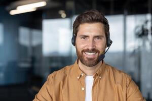 Mature business man smiling in a modern office while wearing a headset. Professional demeanor suited for virtual meetings, customer support, or consultations. Shows confidence and approachability. photo