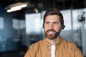 Mature businessman wearing headset smiling while working in modern office environment. Demonstrates professionalism, excellent communication skills ideal for customer support or service role. photo