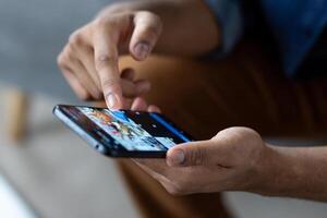 A person uses a smartphone, touching the screen with a finger. Focus is on the hand and device, suggesting interaction and connectivity. photo