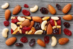Cereal bar with nuts and dried fruits on rustic wooden table photo