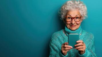 Smiling older woman with curly hair holding a smartphone in front of a bright blue background during the daytime photo