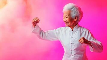 Elderly woman practicing martial arts in a colorful environment while exhibiting strength and joy during an indoor training session photo