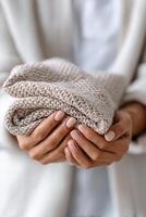 Cozy knitted blanket held in hands for a homely atmosphere and relaxation space photo