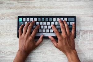 Overhead View of Hands Typing on a Gray and White Keyboard photo