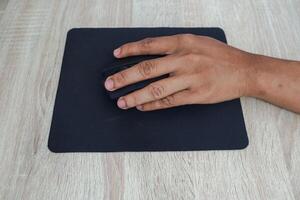 Hand Using Computer Mouse On Wooden Desk photo