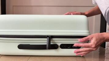 Female hands trying to open the digital lock on a suitcase. The woman forgot the password to the lock on the suitcase. video