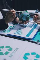 Recycle business concept with green recycling symbol and people working on paper photo