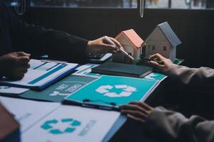 A couple of people are working on a house with a recycling symbol photo