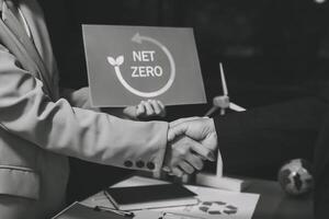 Two people shaking hands with a net zero sign photo