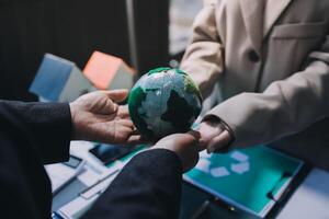 Two people holding a green globe in their hands photo