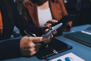 Business people using mobile phones and tablet computers at a desk photo