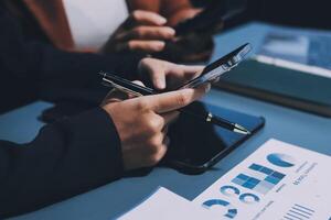Business people using their smartphones to check their financial data photo