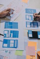 A person is working on a design project with paper and pens photo
