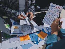 A person is working on a project with papers and a pen photo
