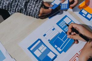 Two people working on a project with paper and blue and white paper photo
