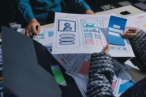 A group of people working on a project with a paper and pen photo
