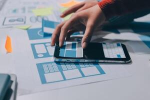 A person using a smartphone to design a website photo